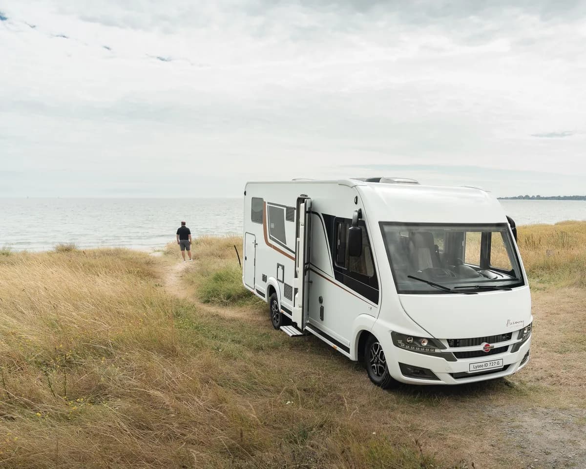 Husbil parkerad på strandäng vid havet